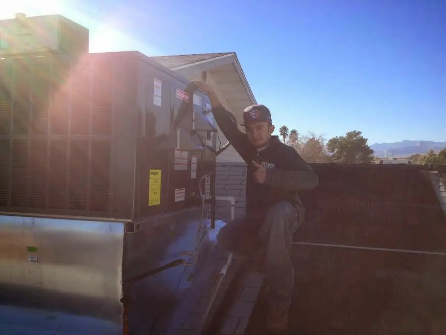 HVAC technician performing Air Duct Repair on a rooftop unit in Tyrone