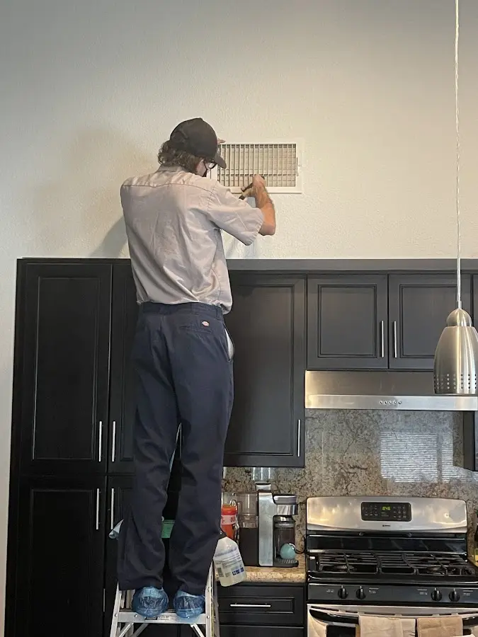 Technician inspecting an air vent during HVAC service in Tyrone